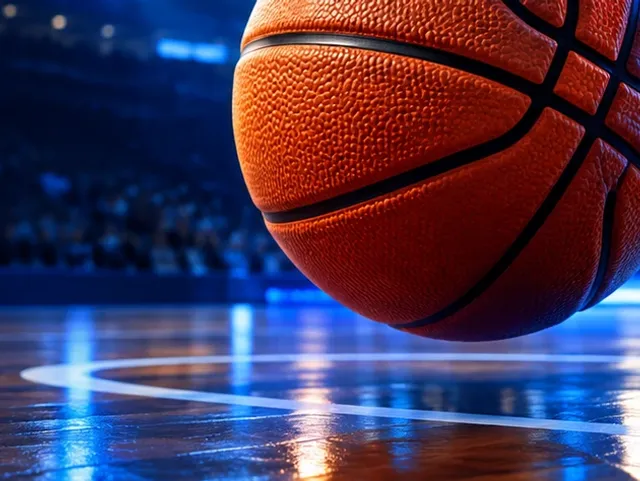 Basketball on a lit court floor