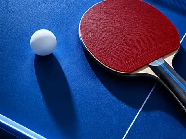 Table tennis bat and ball on a blue table
